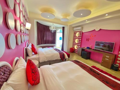 a pink room with two beds and a tv at Dream Ocean View B&B in Magong