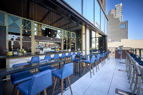 a bar with blue chairs in a building at Archer Hotel New York in New York