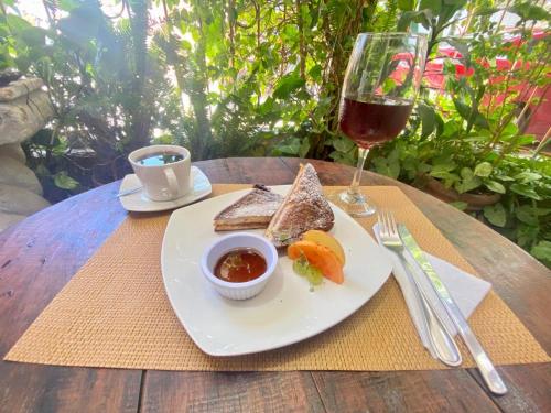 a table with a plate of food and a glass of wine at Hotel Casa Tenango in Cobán