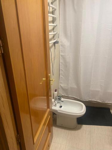 a bathroom with a toilet and a shower curtain at Habitación Almería capital in Almería