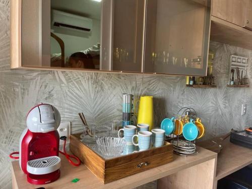 eine Küchentheke mit einem roten Mixer und Tassen darauf in der Unterkunft Flat Eco Resort Carneiros in Rio Formoso