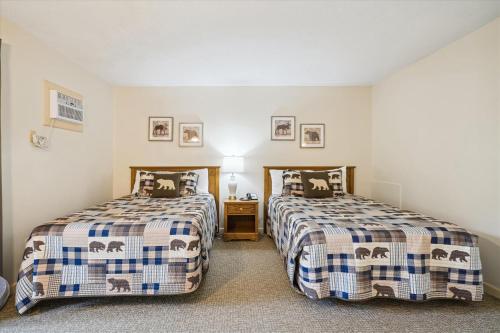 a bedroom with two beds and a night stand at Cedarbrook Hotel Room w/2 doubles 101 in Killington