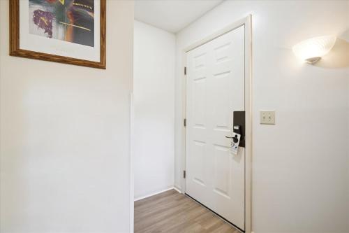 a hallway with a white door and a picture on the wall at Cedarbrook Hotel Room w/2 doubles 101 in Killington