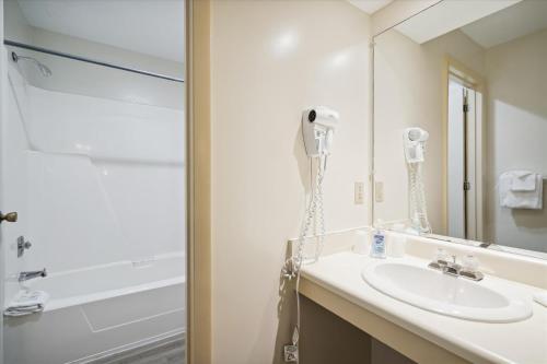 a bathroom with a sink and a shower and a mirror at Cedarbrook Hotel Room w/2 doubles 101 in Killington