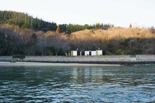a view of a body of water with a beach at 離島-宿navelの学校-三原港から船で14分 in Mihara