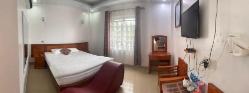 um quarto com uma cama e uma televisão em Khách Sạn Phương Thuý em Yen Bai