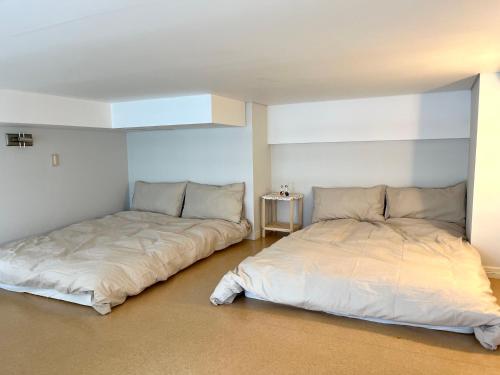 two beds sitting next to each other in a room at Hongdae Station loft apartment in Seoul