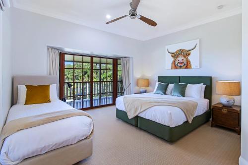 a bedroom with two beds and a cow on the wall at The Golden Whistler Montville in Montville