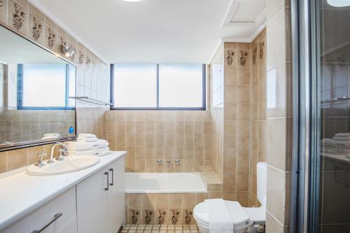 黄金海岸Beachfront & City View, Huge 2 Bedroom Apartment, Imperial Surf Resort的带浴缸、水槽和马桶的浴室