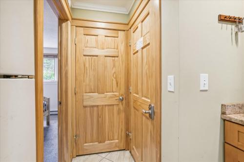 eine Holztür in einer Küche neben einem Kühlschrank in der Unterkunft Cozy one bedroom Edgemont A1 condo on the shuttle route & ski back trail in Killington