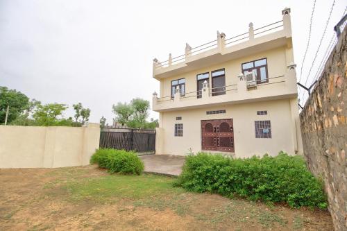 uma casa com um portão e uma cerca em OYO Hotel Kukas Guest House em Jaipur