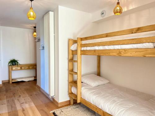 une chambre avec deux lits superposés dans une pièce dans l'établissement Appartement neuf aux Gets, proche remontées mécaniques, terrasse sud, 6 couchages, garage, WiFi - FR-1-623-350, aux Gets