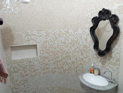 a bathroom with a sink and a mirror on the wall at Mini Casa Furnas - Capitólio MG in São José da Barra