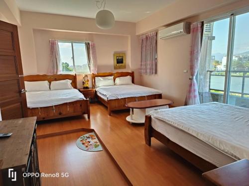 a hotel room with two beds and a window at 茶樂二重奏 in Taitung City