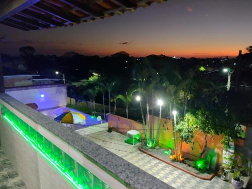 Habitación con vistas a un balcón con luces por la noche. en Recanto dos Loureiros en Saquarema