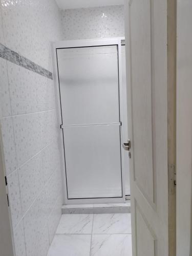 a bathroom with a white shower stall and a door at Complejo Valentina in Villa Mercedes