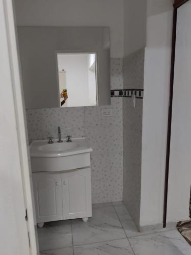 a white bathroom with a sink and a mirror at Complejo Valentina in Villa Mercedes