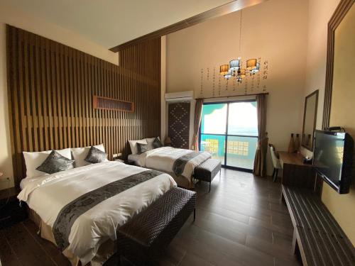 a hotel room with two beds and a television at The Domed Tile B&B in Magong