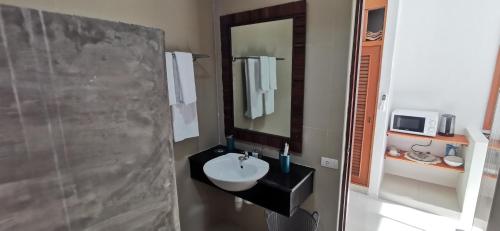 La salle de bains est pourvue d'un lavabo et d'un miroir. dans l'établissement DB Studios Samui, à Lamai