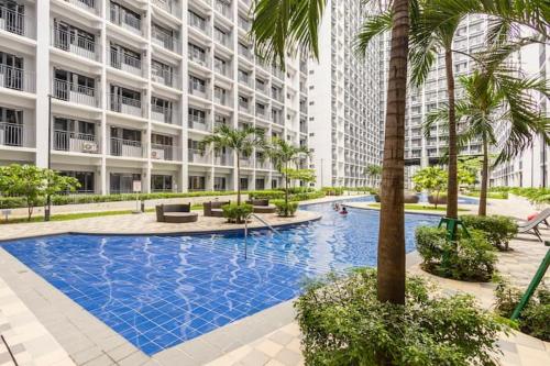 a large apartment building with a large swimming pool at Shore 2 Residences 1BR Deluxe Room in MOA Complex in Manila