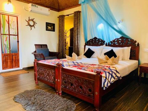 a bedroom with a large bed with a blue canopy at Maadathil Cottages & Beach Resort in Varkala