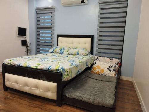 um quarto com uma cama com uma cabeceira branca em Home in Bacolod em Bacolod