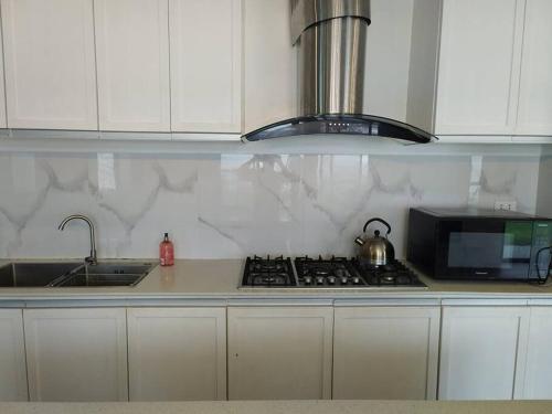 a kitchen with a stove top and a microwave at Home in Bacolod in Bacolod