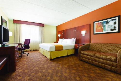 a hotel room with a bed and a couch at Radisson Akron-Fairlawn Copley in Fairlawn