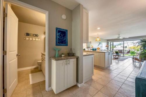 a large kitchen with white cabinets and a counter at Hale Kamaole 7-169- Ground floor, ocean view, updated Kihei gem in Wailea