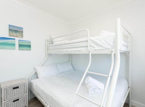 a bedroom with a bunk bed with a ladder at Edgewater 1 - LJHooker Yamba in Yamba