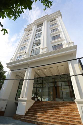 um grande edifício branco com escadas em frente em TQ Hotel & Apartment em Hai Phong