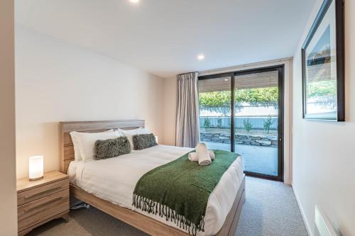 a bedroom with a bed and a large window at Central Vista in Wanaka in Wanaka