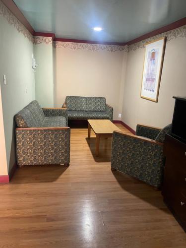 a waiting room with couches and a table and a tv at Provo Inn & Suites in Provo