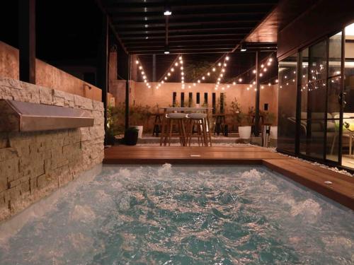 a swimming pool in a house with a table and chairs at Seacove Villa w/ Heated Jacuzzi in Laiya Batangas in San Juan