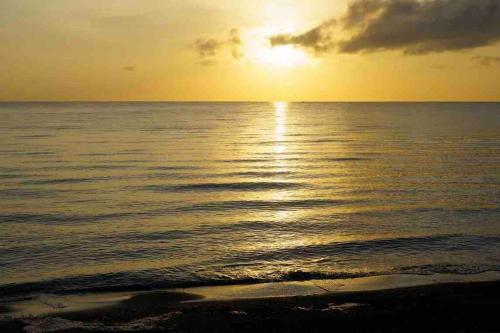 a sunset over the ocean with the sun setting at Seacove Villa w/ Heated Jacuzzi in Laiya Batangas in San Juan