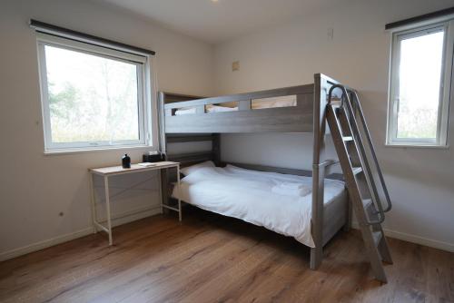 a small bedroom with a bunk bed and a ladder at Soga House in Kabayama