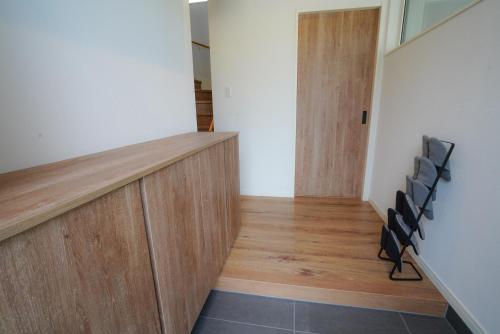 a hallway of a house with a staircase and chairs at Soga House in Niseko