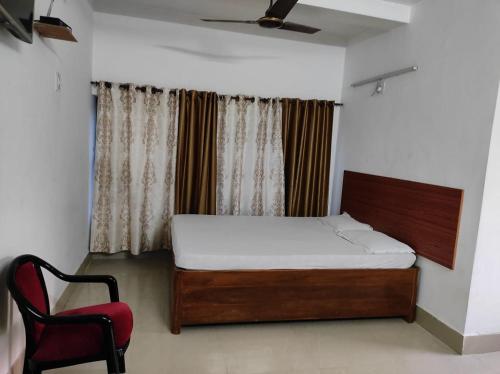 a bedroom with a bed and a red chair at PAGODAINN in Konārka
