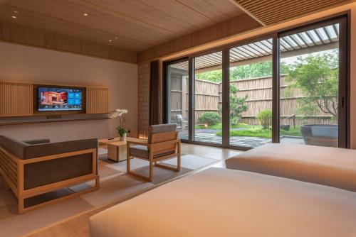 a bedroom with two beds and a flat screen tv at Hyakumangoku Onsen Hotel in Shanghai