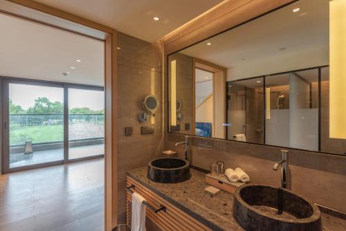 a bathroom with two sinks and a large mirror at Hyakumangoku Onsen Hotel in Shanghai