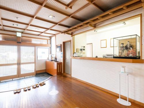 una habitación con un bar con zapatos en el suelo en Tabist Fuji Sakura Onsen Ryokan en Fuefuki