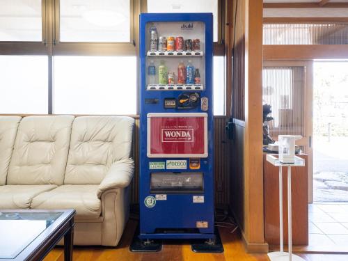 a vending machine next to a couch in a room at Fuji Sakura Onsen Ryokan in Fuefuki