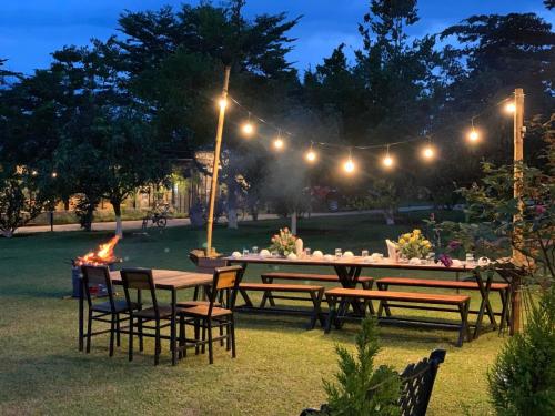 a group of tables and chairs in a yard with lights at JE T'AIME VILLA - Khu nghỉ dưỡng nhà vườn nằm giữa thiên nhiên bao la hoa cỏ in Bao Loc