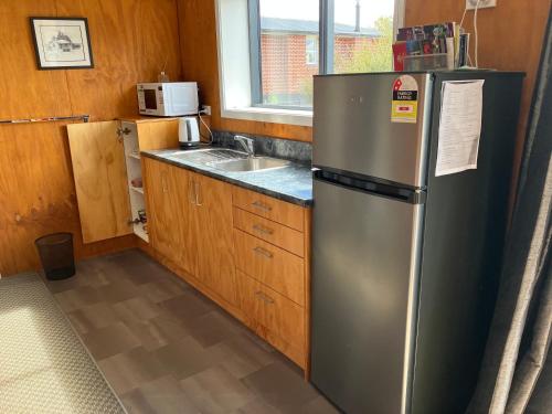 a kitchen with a stainless steel refrigerator and a sink at Southland Farming Retreat in Gore