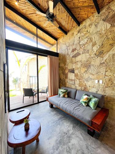 a living room with a couch and a stone wall at DIEM Vichayito Beachfront Eco-Luxury in Vichayito