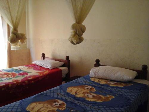 1 dormitorio con 2 camas con perros. en Majestic Tourist Hotel, en Kandy