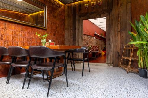 a bar with black chairs and a brick wall at Rinvada House in Bangkok