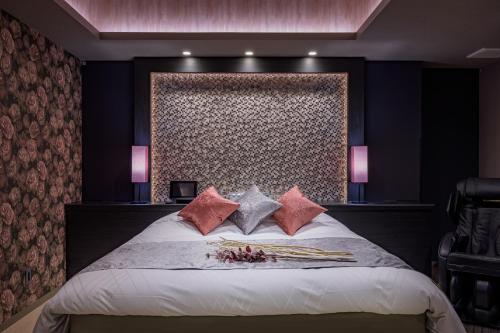 Un dormitorio con una cama grande con almohadas rosas. en ホテル シードット 横浜 トレ, en Yokohama