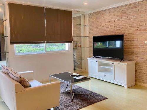 a living room with a couch and a television at PACIFIC RESIDENCE 39 in Bangkok