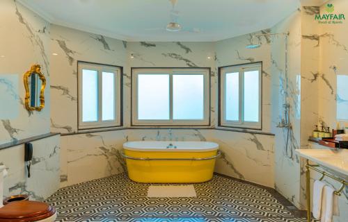 a bathroom with a large yellow tub in a room at Mayfair Spring Valley in Guwahati